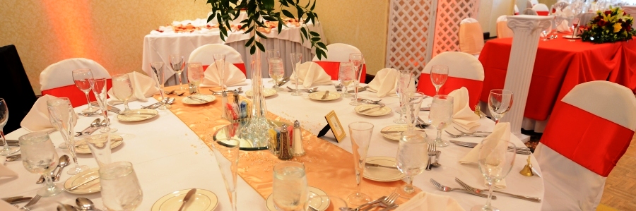 white chair cover with red satin sash and gold table runner
